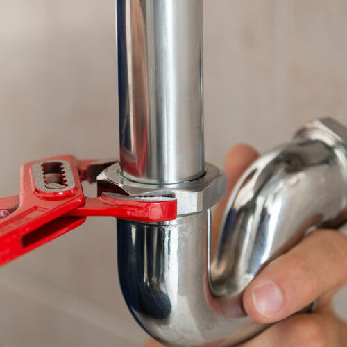 Plumber adjusts a pipe.